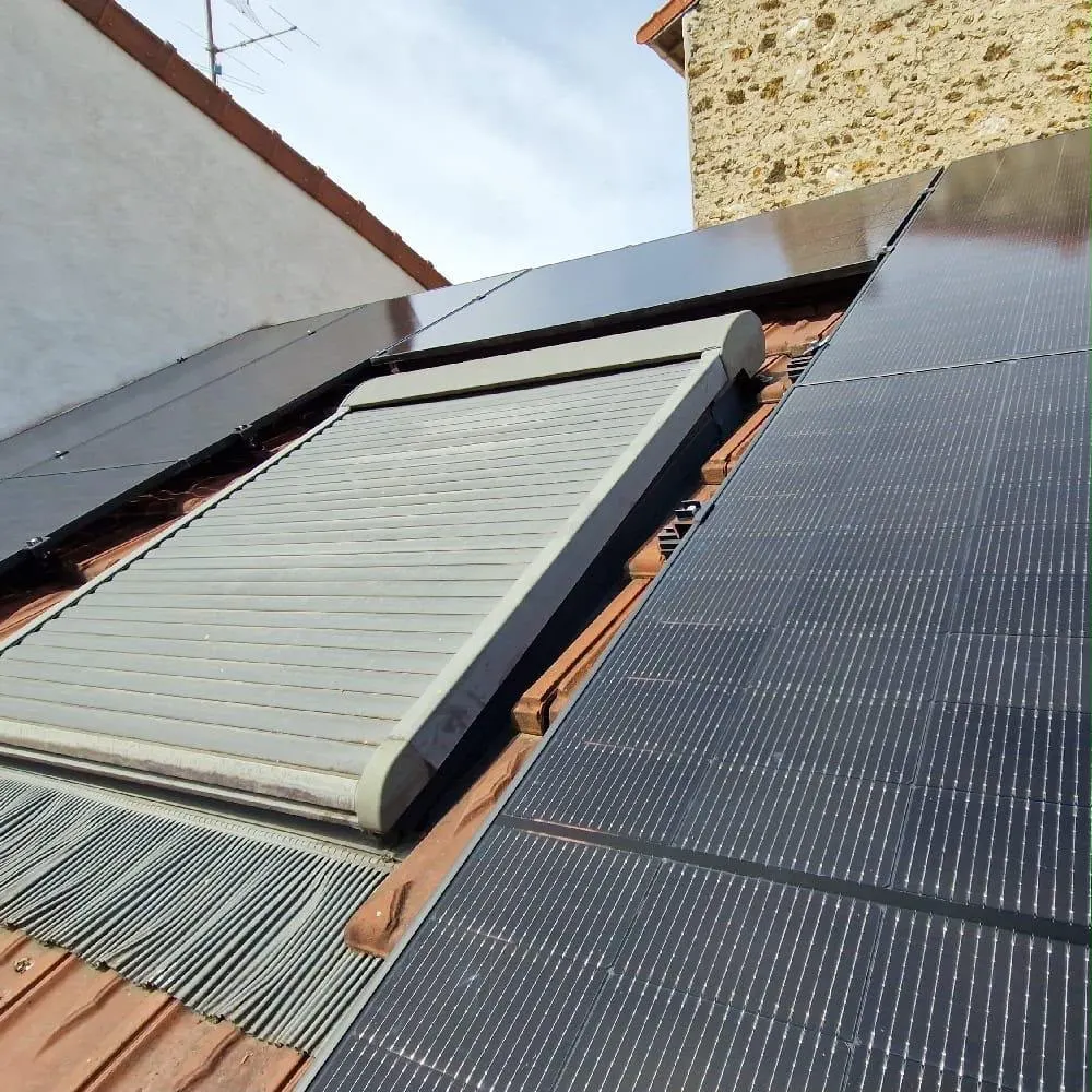Panneaux photovoltaïques installés à côté d'un velux sur une toiture